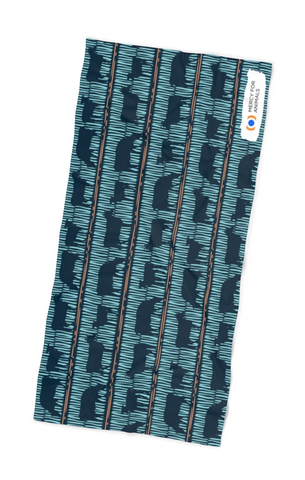 A blue beach towel with a pattern of cow silhouettes.