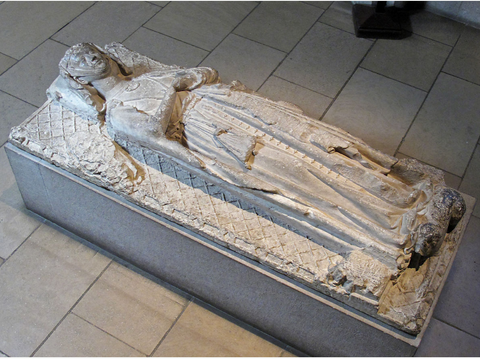 The Tomb Effigy of a Lady, a white stone tomb topper piece of a woman in medieval garb.