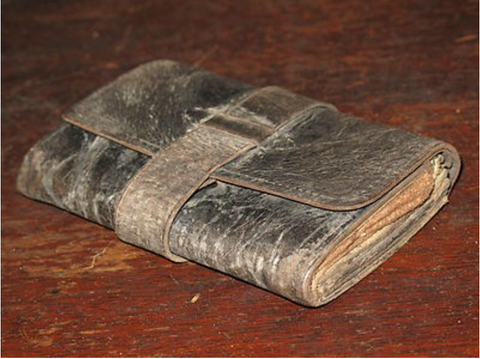 A very old leather wallet, closed.
