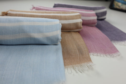 Four rolled-up scarves in various colors.