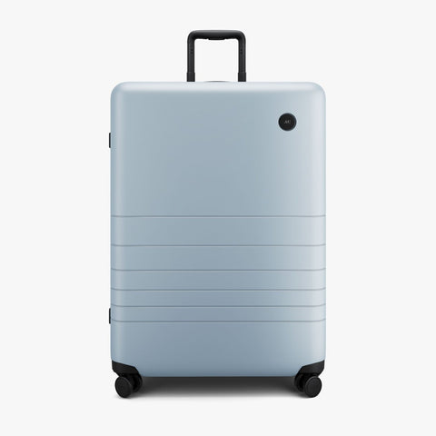 A grey hardshell suitcase with black hardware.