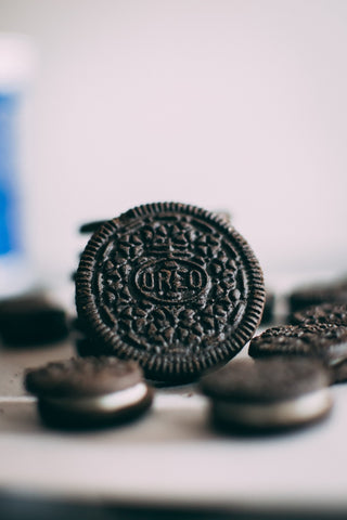 An Oreo cookie sits face up on a stack of others.