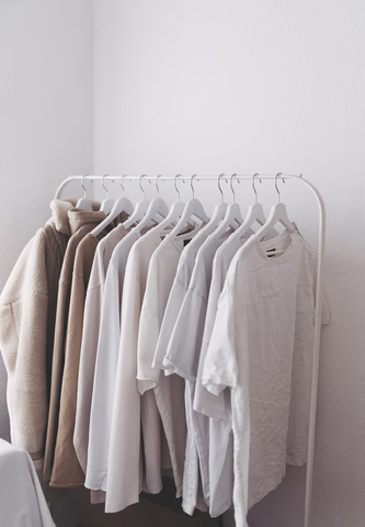 A row of white shirts on hangers.
