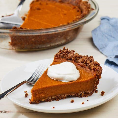 A slice of dark orange pumpkin pie with whipped cream on top.