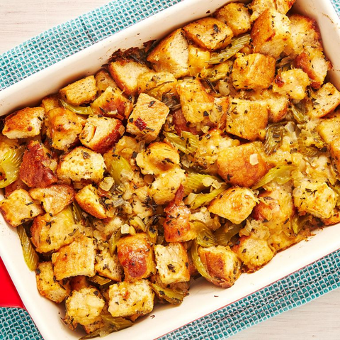 A casserole dish of stuffing. There are visible chunks of bread mixed with various seasonings.