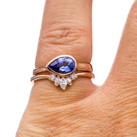 Bridal rose gold ring stack with pear tanzanite engagement ring and curved Macie wedding band