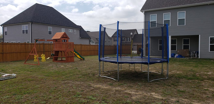 backyard with a trampoline and a playset