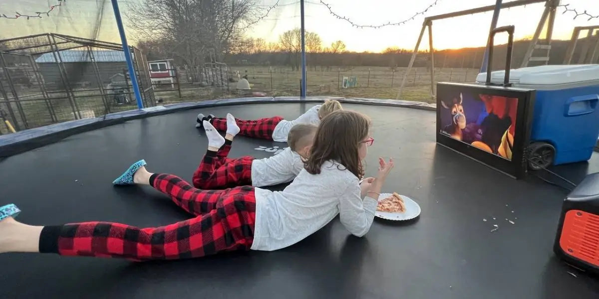 Kids watching a movie on a trampoline
