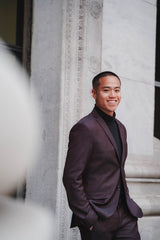 Image from Zahire- Namane - Asian man smiling at the camera wearing a burgundy suit. 