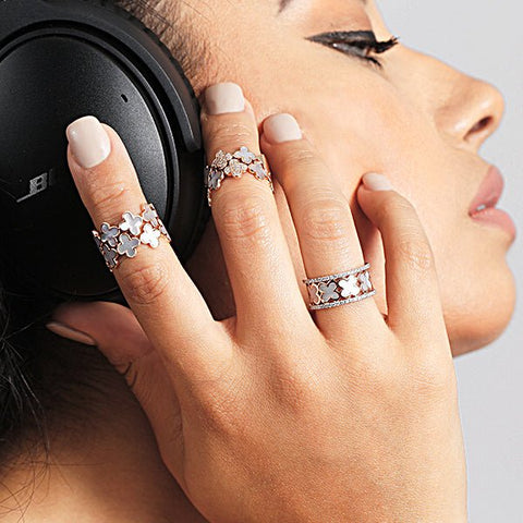 A woman listening to headphones and wearing cocktail rings by Estella Collection