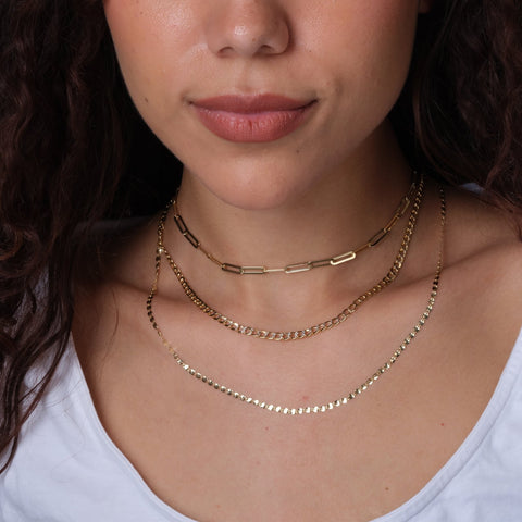 A woman wearing gold necklaces by Estella Collection
