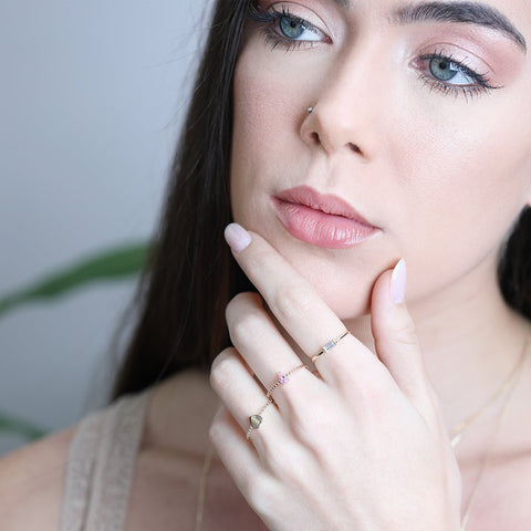 A woman wearing stacking rings by Estella Collection