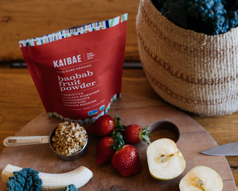 KAIBAE prebiotic Baobab superfood powder and a basket of organic fruits, nuts adn vegetables