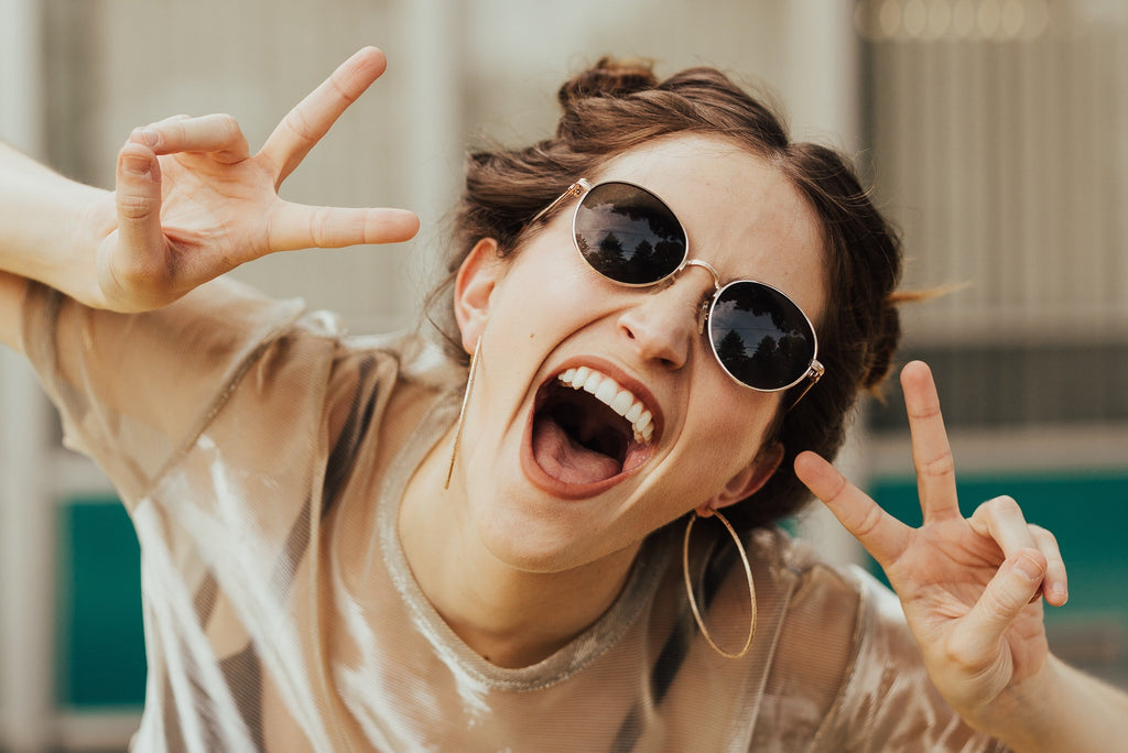 woman smiling at the camera wondering does drinking water help with acne