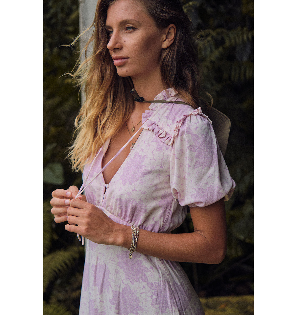 A woman wearing Yvonne Dress floral lilac in a house