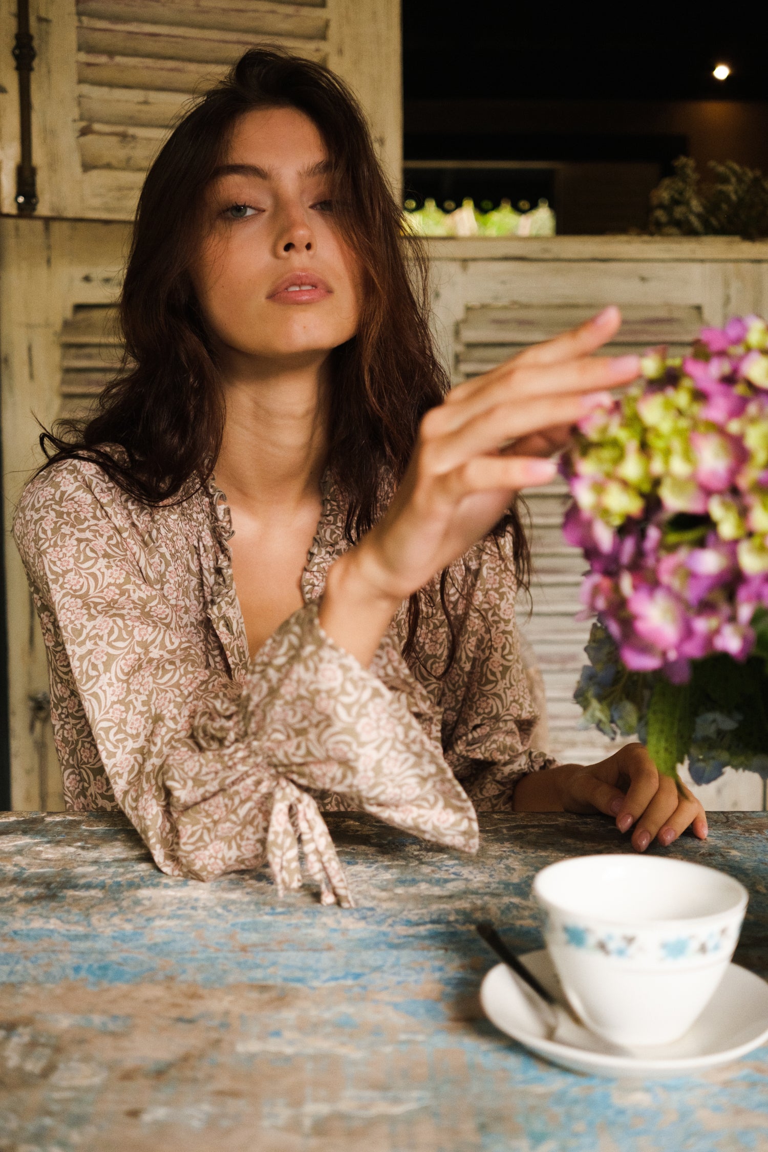 girl with floral dress sitting at a table