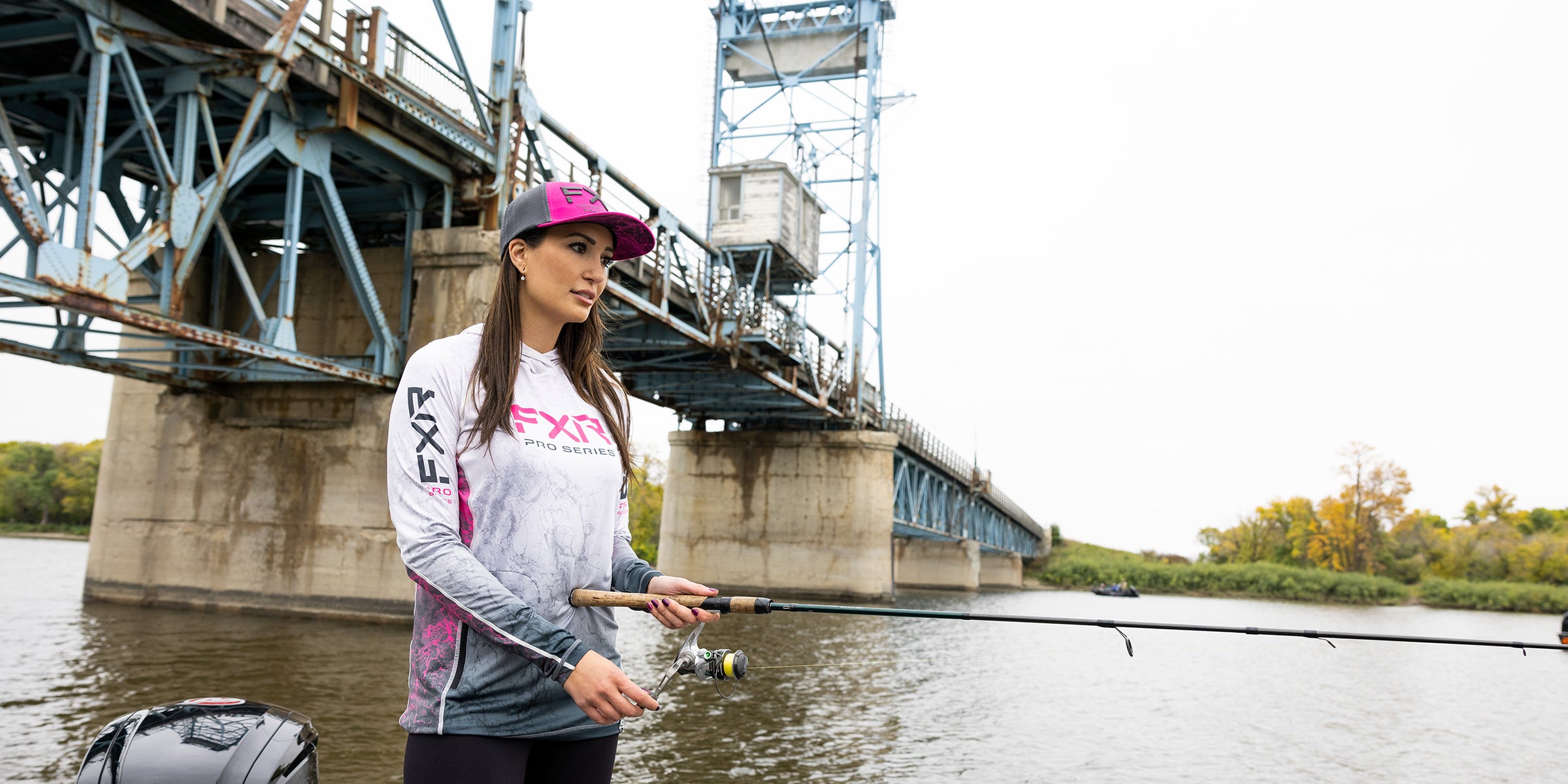 Image of a woman out fishing in FXR's Attack UPF Pullover Hoodie in blue fade/ice colorway
