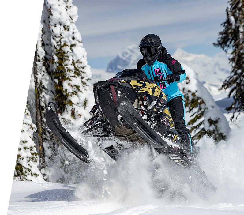 Shot of a woman on snowmobile wearing FXR's Women's Recruit Monosuit