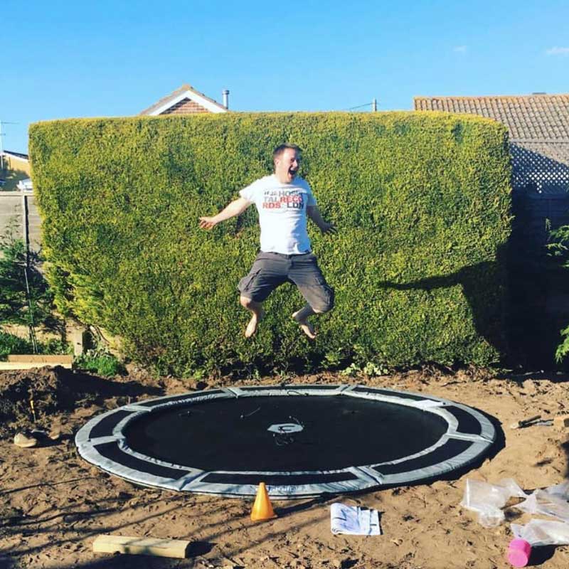 happy man on capital in-ground trampoline