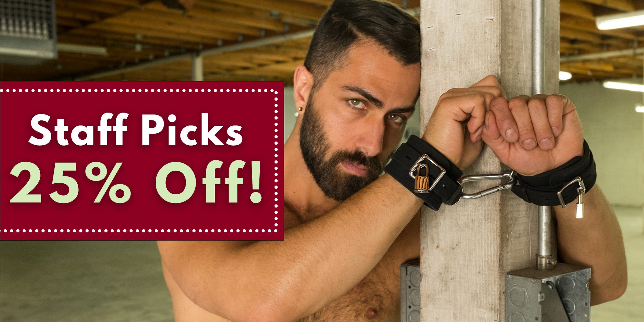 A man is seen facing camera and his hands are restrained around a column with silicone bondage wrist cuffs. Male Stockroom Holiday Gift Guide Sale: Staff Picks.