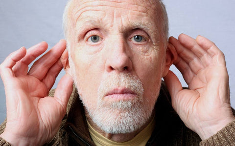 Elderly man holding his ears forward