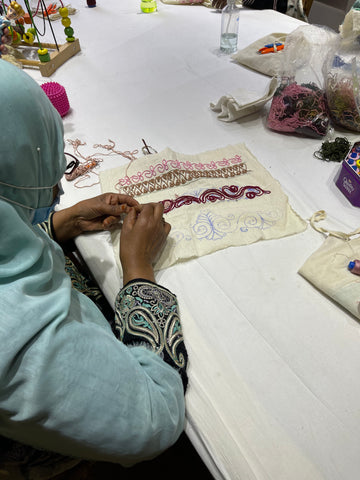 Una imagen de una mujer haciendo bordado.