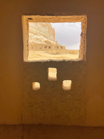 Une image d’un paysage désertique à travers une petite fenêtre.