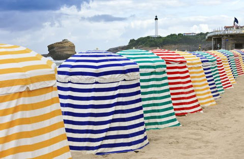 An image of striped tents on the beach.