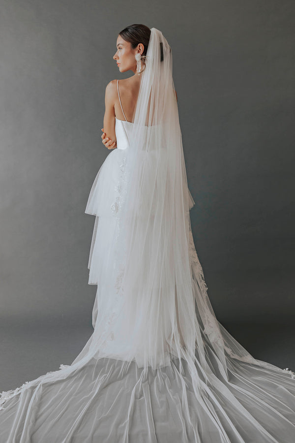 This extreme wedding dress features a hat and a full body veil as well as a  feathery poof around the