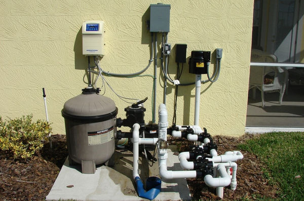 Technician installing a Pentair WhisperFlo pump at poolside.