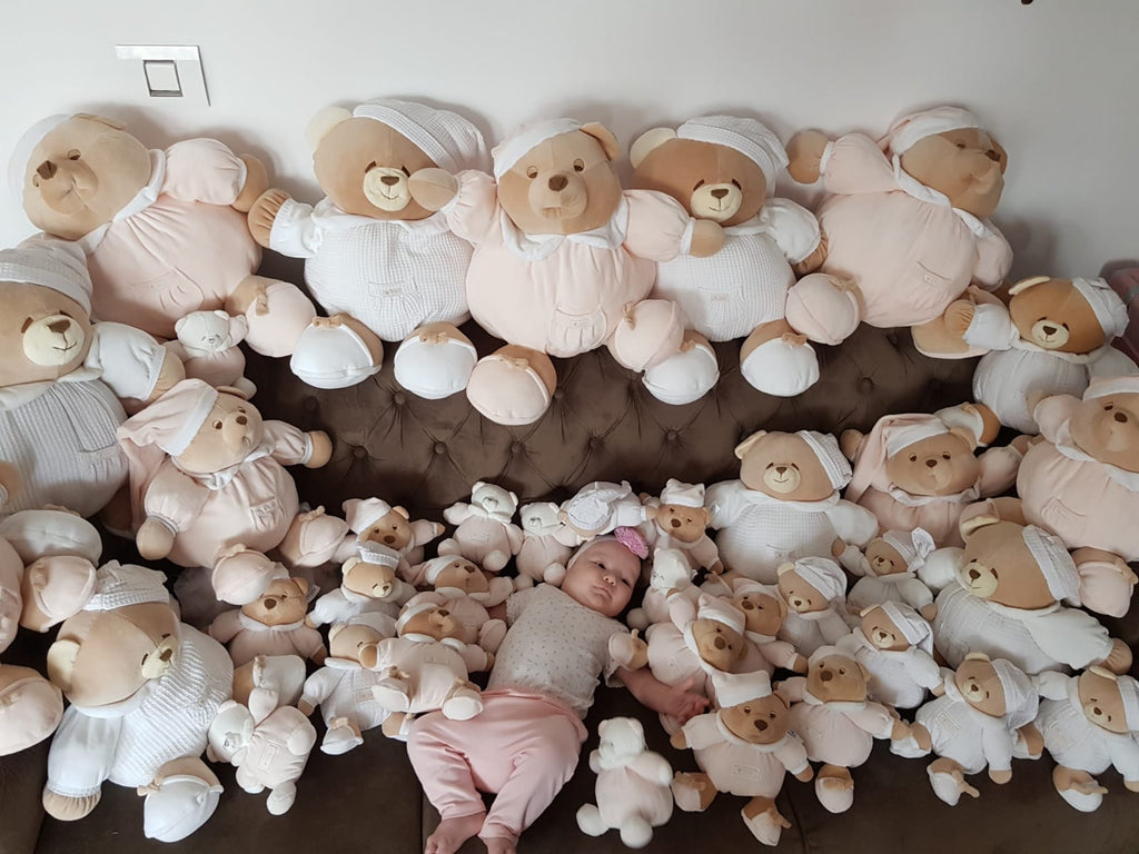 baby surrounded by teddy bears baby room