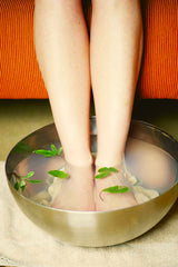 woman soaking her feet in a bowl of water 