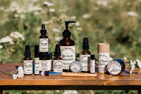 Botanical Bee Apothecary's all natural artisan skin care concentrate collection in a Yarrow field on our farm on a sunny day.