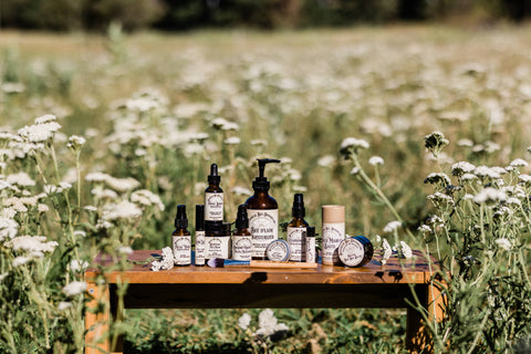 Botanical Bee Apothecary's all natural artisan skincare concentrate collection in a Yarrow field on our farm on a sunny day.