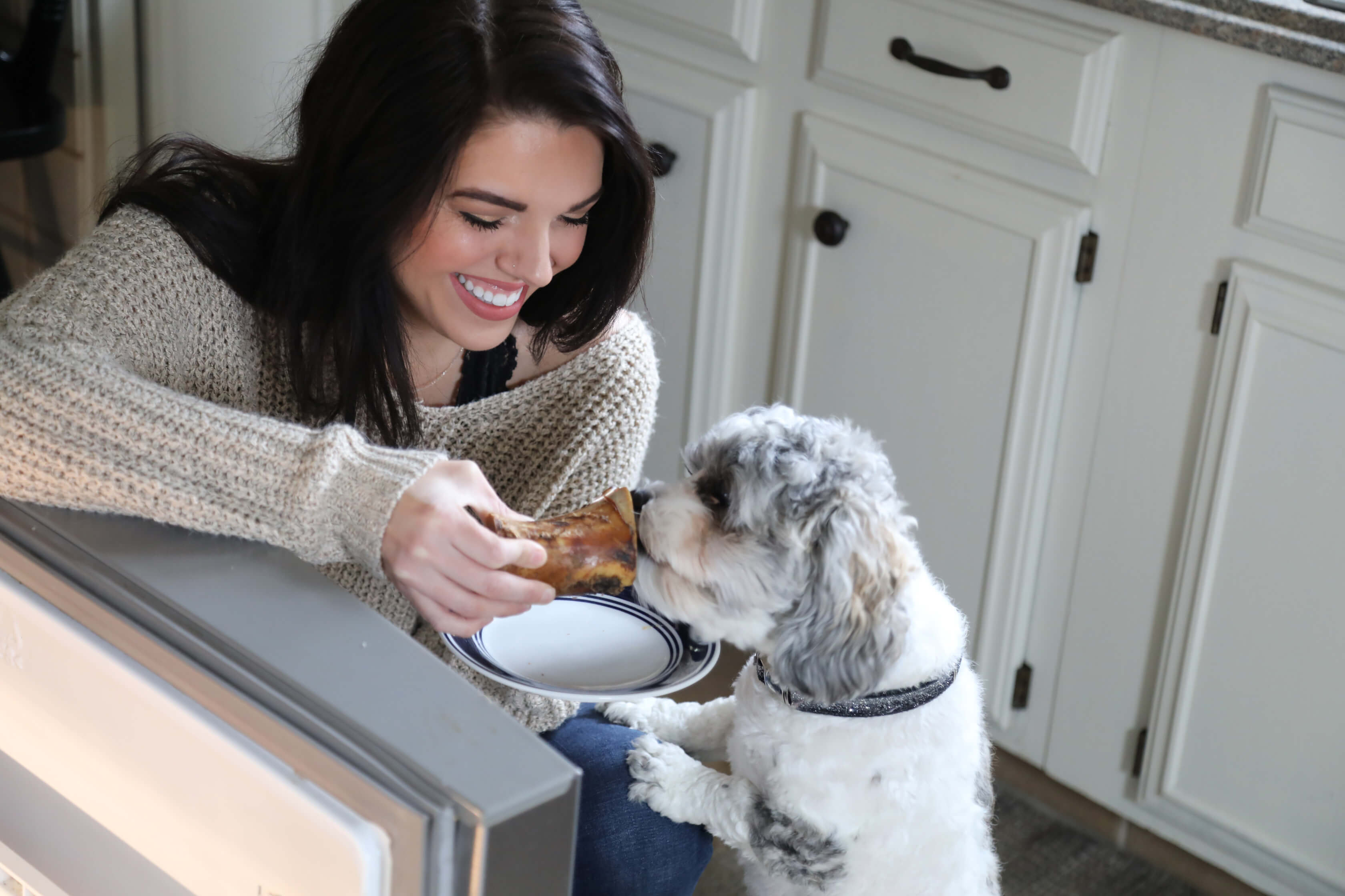 girl giving dog beef marrow bone