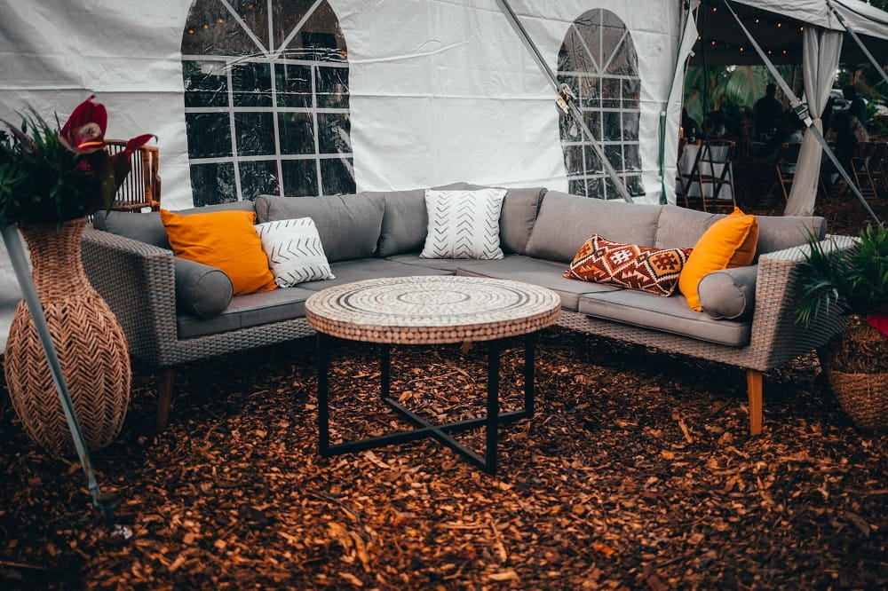 The outdoor sofa lay on the ground covered with fallen leaves