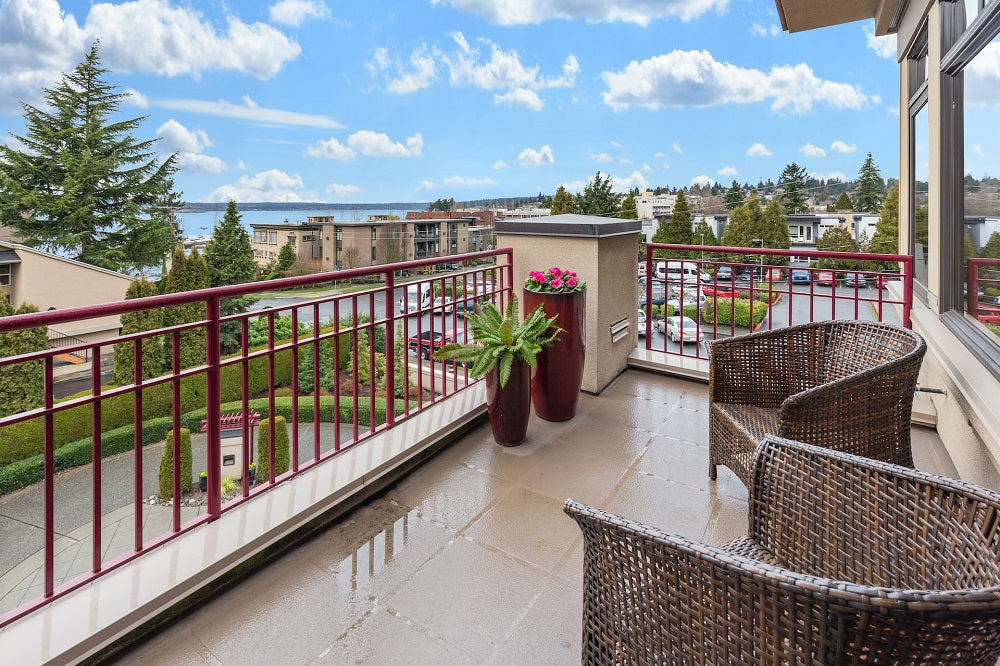 There are two rattan chairs on the balcony