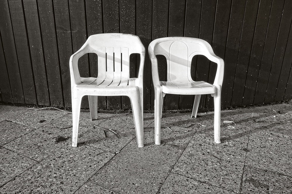 Two white plastic chairs stand in the corner