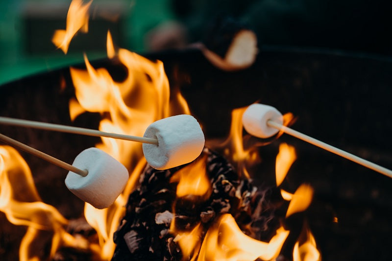 Use a skewer to stick marshmallows on the fire pit