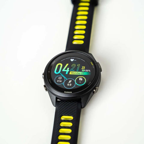 The Black and Amp Yellow Garmin Forerunner 965 with AMOLED display laid flat on a white table