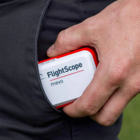 FlightScope Mevo launch monitor being put in a front pants pocket to show small size