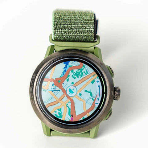 A Coros Apex 2 with green watch band and color maps on the display