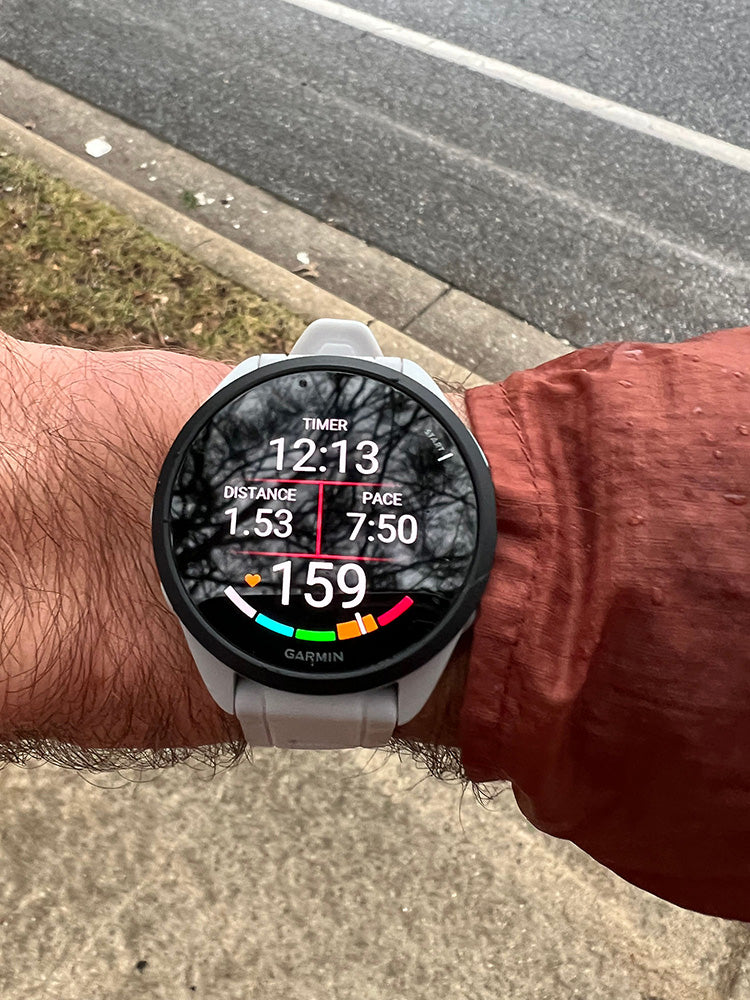 The Garmin Forerunner 165 running watch on Chris's wrist with GPS time, distance, pace and heart rate
