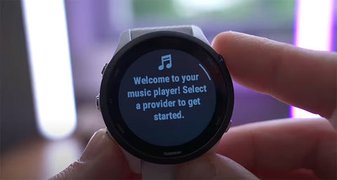 A Garmin Forerunner 255 showing the music player on the display