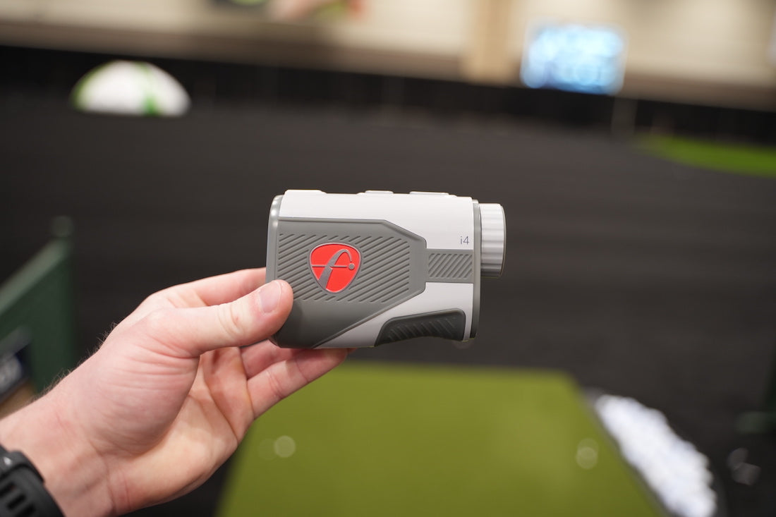 PlayBetter team member's hand holding the FlightScope i4 golf rangefinder at the PGA Show
