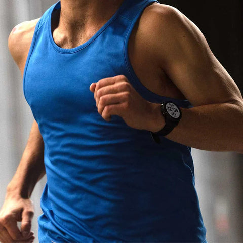 The torso of a man running wearing a black Garmin Forerunner 255 on his wrist