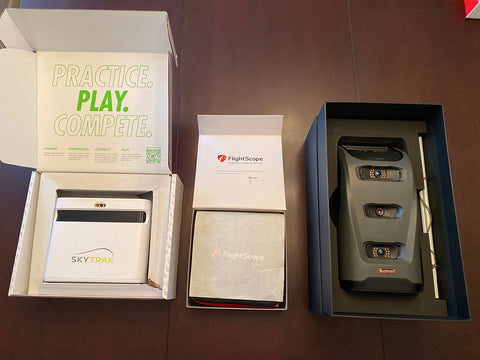 The SkyTrak+, FlightScope Mevo+ and Bushnell Launch Pro laying in opened boxes