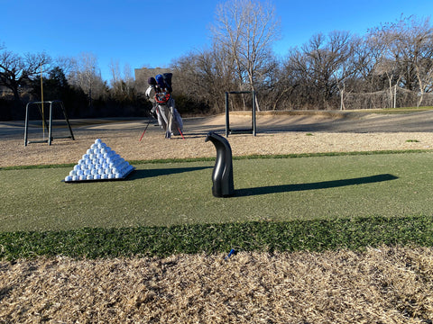 The Bushnell Launch Pro on the golf range near a pyramid of golf balls