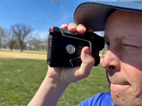 Marc on the golf course with the Bushnell Pro X3+ rangefinder up to his face