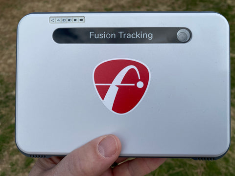 The FlightScope Mevo+ Limited Edition launch monitor held by Marc, showing his thumb at the bottom